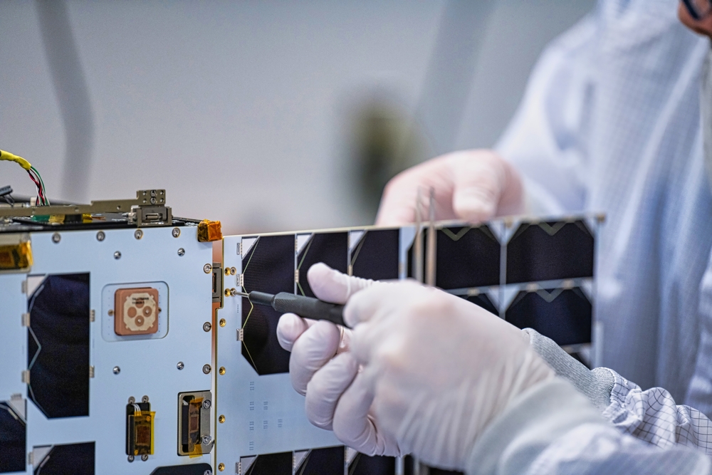 Technicians assemble a small satellite